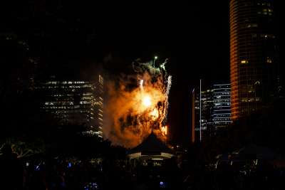 Fireworks lighting up swirling clouds of smoke between tall buildings in Dallas