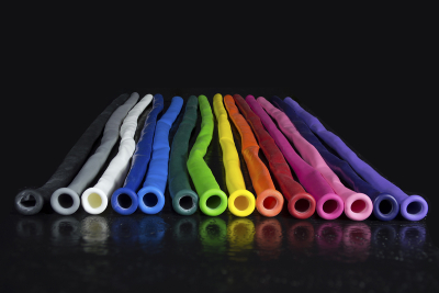 Rainbow of colorful uninflated balloons lined up on black background